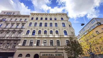 Historische Fassade eines Gebäudes mit Kino im Erdgeschoss und vielen Fenstern.