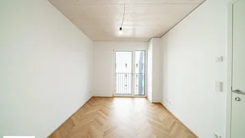 Helles Schlafzimmer mit Fischgrätparkett, Holzbalkendecke und Zugang zu einem französischen Balkon.