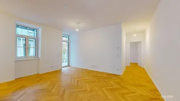 Helles, leeres Zimmer mit Fischgrätparkett und Zugang zu einem Balkon oder einer Terrasse.