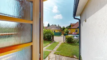 Blick aus dem verglasten Anbau auf die Einfahrt und die Nachbarschaft.