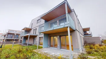 Moderne Wohnanlage mit Holzfassade, Balkonen und Terrassen in grüner Umgebung.