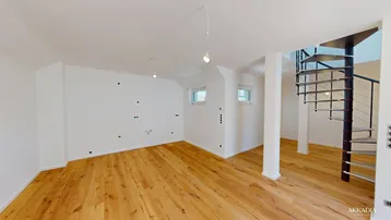 Helles Zimmer mit Holzparkettboden und einer eleganten Wendeltreppe, ideal als Wohn- oder Arbeitsbereich.