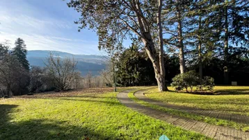 Idyllischer Gartenweg mit weitem Blick auf die umliegende Landschaft und Berge.