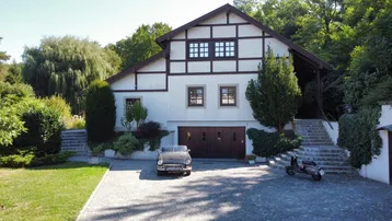 Traditionelles Haus mit Fachwerkdetails, großer Auffahrt und integrierter Garage.
