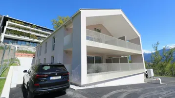 Neubau-Wohngebäude mit moderner Architektur und Balkonen in sonniger Lage.