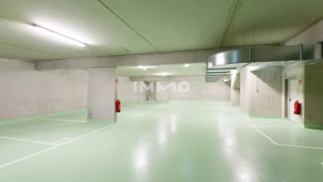 Geräumige Tiefgarage mit hellgrünem Boden, Betonwänden und effizienter Beleuchtung für mehrere Stellplätze.
