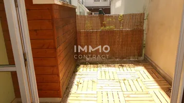 Kleiner, privater Außenbereich mit Holzdielen und Bambuszaun, ideal zum Entspannen im Freien.