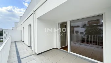 Geräumige Terrasse mit Fliesenboden und Blick auf die Umgebung, ideal für Entspannung im Freien.