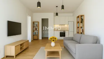 Helles, offenes Wohnzimmer mit integrierter Küche, Parkettboden und modernen Möbeln.