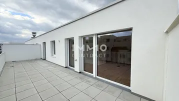 Geräumige Dachterrasse mit modernen Fliesen und Zugang zu den Innenräumen, ideal für Entspannung im Freien.