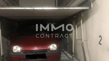 Mechanische Parkplattform in einer Tiefgarage mit einem geparkten Auto und sichtbaren Rohren.