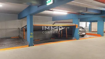 Moderne Tiefgarage mit Doppelparker-System, blauen Trägern und Betonwänden für effizientes Parken.