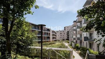 Moderner Wohnkomplex mit begrüntem Innenhof und Wegen zwischen den Gebäuden.