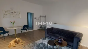 Heller Wohn- und Essbereich mit bequemer Couch, Esstisch und Holzboden, ideal für entspannte Stunden.