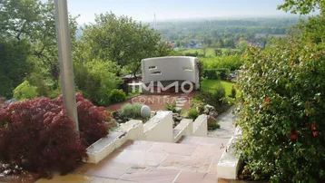 Steintreppe im Garten mit weitem Blick über die Landschaft und grüne Umgebung.