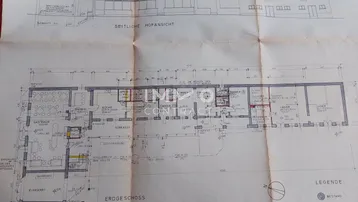 Detaillierter Grundriss des Erdgeschosses mit Gastraum, Küche und weiteren Zimmern.