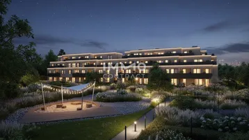 Moderne Wohnanlage bei Nacht mit beleuchteten Wegen und gepflegter Gartenlandschaft.