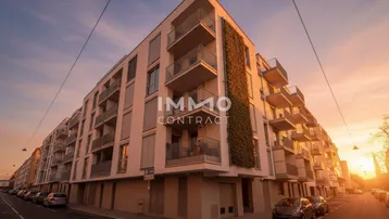 Modernes Wohngebäude mit Balkonen und vertikaler Begrünung bei Sonnenuntergang in urbaner Umgebung.