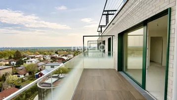 Geräumiger Balkon mit Holzboden und weitem Blick über die Umgebung und die Stadt.