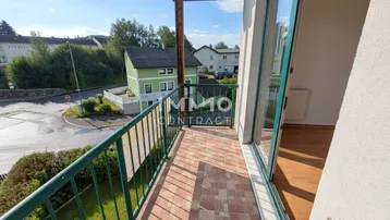 Balkon mit Fliesenboden und Blick auf die Umgebung und eine Straße.