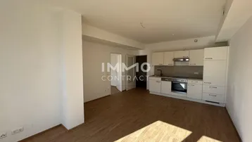 Helles, offenes Wohnzimmer mit integrierter Küche und Holzfußboden in modernem Stil.