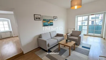 Helles Wohnzimmer mit Parkettboden, bequemen Möbeln und Zugang zu einem französischen Balkon.