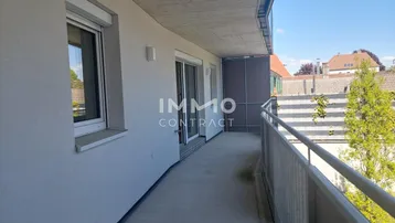 Langer, schmaler Balkon mit Metallgeländer und Blick auf die Umgebung.