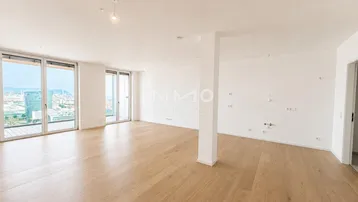 Helles, geräumiges Wohnzimmer mit Holzboden und großen Fenstern mit Stadtblick.
