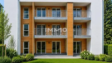 Moderne Wohnanlage mit weißer Fassade, Holzverkleidung und Balkonen, umgeben von Grünflächen.