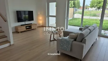 Helles Wohnzimmer mit modernem Laminatboden, großen Fenstern und direktem Zugang zum Garten.