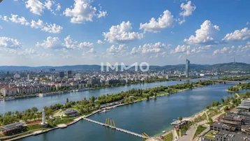 Panoramablick über die Stadt mit Fluss, Brücken und moderner Architektur unter blauem Himmel.