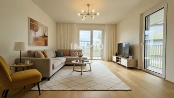 Helles Wohnzimmer mit modernem Sofa, Holzboden und Zugang zu einem Balkon.