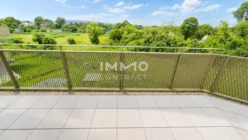 Geräumiger Balkon mit modernem Metallgeländer und weitem Blick ins Grüne.
