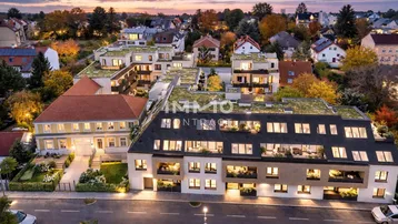 Moderne Wohnanlage mit Gründächern und Balkonen in einer grünen Umgebung bei Sonnenuntergang.