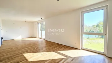 Helles, leeres Wohnzimmer mit Parkettboden und Zugang zu einem Balkon, bereit zur Gestaltung.