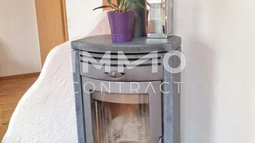 Moderner Kaminofen auf Fliesenboden, der eine gemütliche Atmosphäre im Wohnbereich schafft.