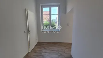 Helles Zimmer mit Laminatboden und Blick ins Grüne, ideal als Schlaf- oder Arbeitszimmer.