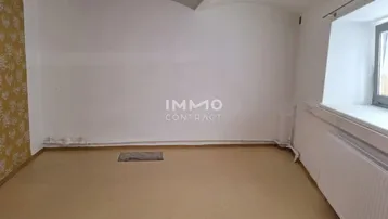 Leerer Raum mit weißen Wänden, einem Fenster und einem Heizkörper, bereit zur individuellen Gestaltung.