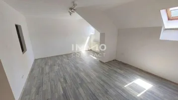 Helles Dachgeschosszimmer mit Laminatboden und Dachfenstern, ideal als Wohn- oder Schlafbereich.