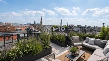 Geräumige Dachterrasse mit bequemen Loungemöbeln und weitem Blick über die Stadt.