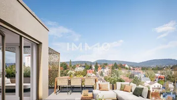 Geräumige Dachterrasse mit Lounge-Möbeln und weitem Blick über die Stadt und Hügellandschaft.