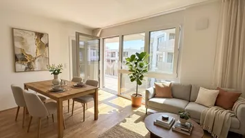 Helles Wohn- und Esszimmer mit Holzboden, Sofa und Esstisch, mit Zugang zum Balkon.