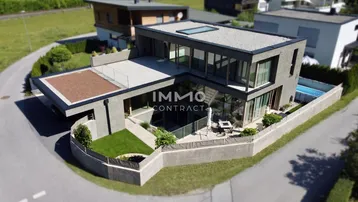 Moderne Villa mit Flachdach, großzügigen Terrassen und integriertem Pool in alpiner Umgebung.