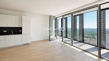 Heller Wohnbereich mit Holzboden, bodentiefen Fenstern und Zugang zu einem Balkon mit Stadtblick.