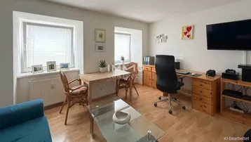 Helles Wohnzimmer mit Holzboden, Esstisch und Arbeitsbereich, ausgestattet mit funktionalen Möbeln.