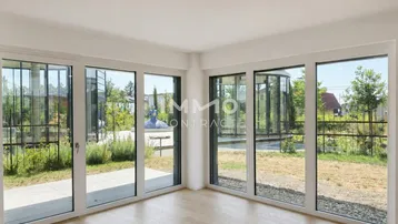 Heller, leerer Raum mit großen Fenstern und Blick ins Grüne, ideal für Wohnzwecke.
