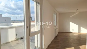 Helles Zimmer mit Holzboden und Zugang zu einer sonnigen Terrasse.