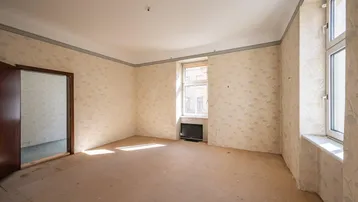 Helles Zimmer mit gemusterter Tapete und zwei Fenstern, bereit zur Renovierung und Neugestaltung.