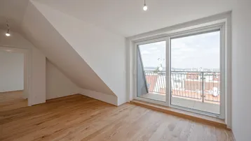 Helles Dachgeschosszimmer mit Holzboden, schrägen Wänden und Zugang zu einem Balkon mit Stadtblick.