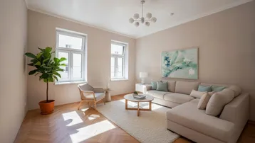 Helles Wohnzimmer mit Fischgrätparkett, beiger Eckcouch und dekorativer Zimmerpflanze.